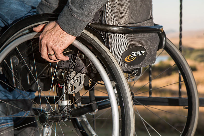 Close up of wheelchair with persons hand on the wheel